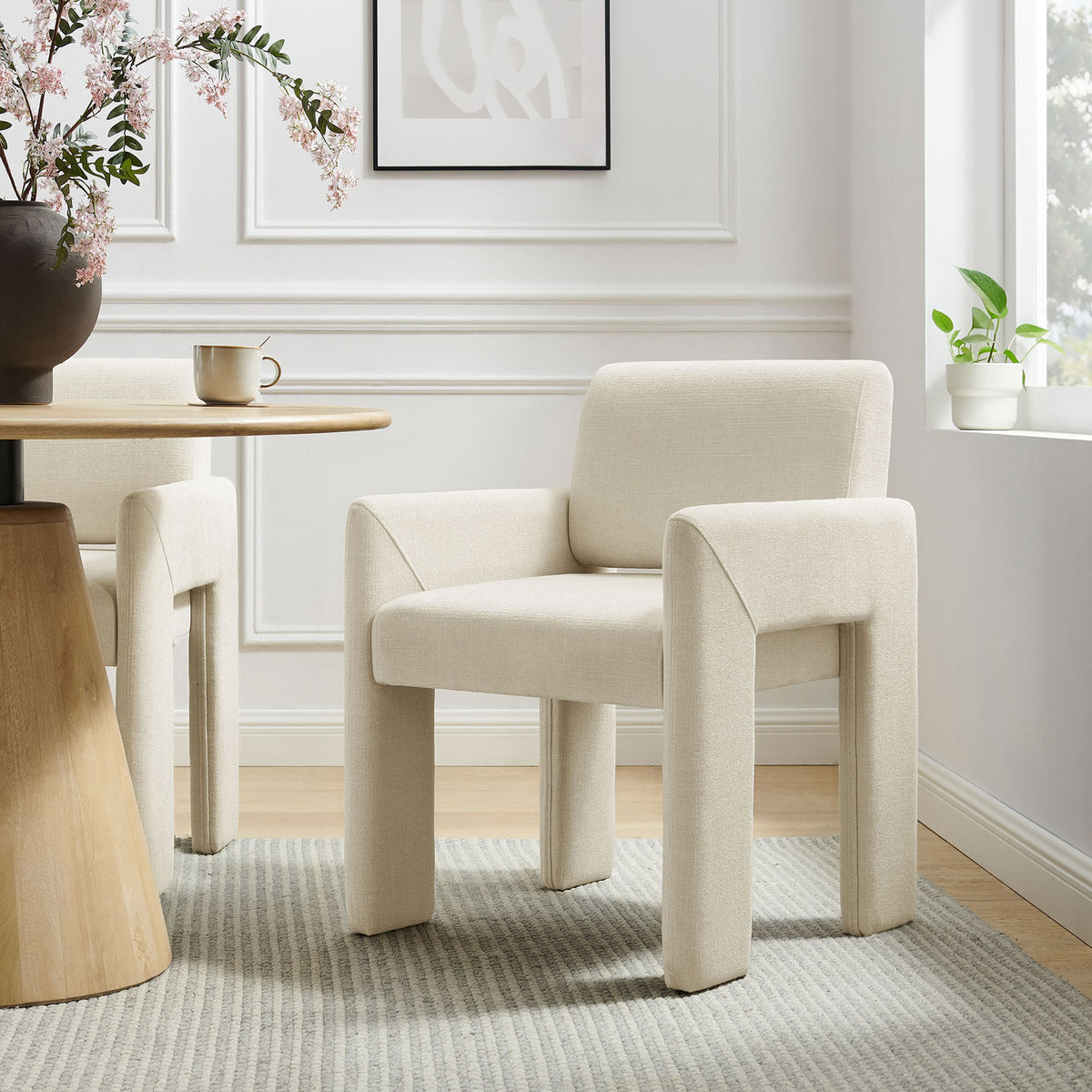 Ecru upholstered dining chair paired with a wood table, adding modern softness to a bright dining space || EEI-7524-ECR || front_angle_room