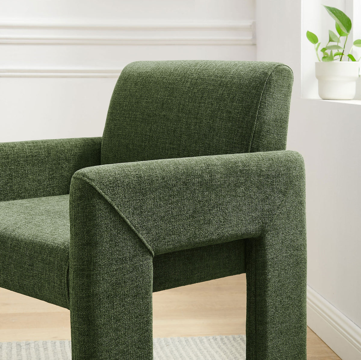 Green upholstered dining chair near a bright window, featuring a gently curved back and padded arm. || EEI-7524-FOL || detail_room
