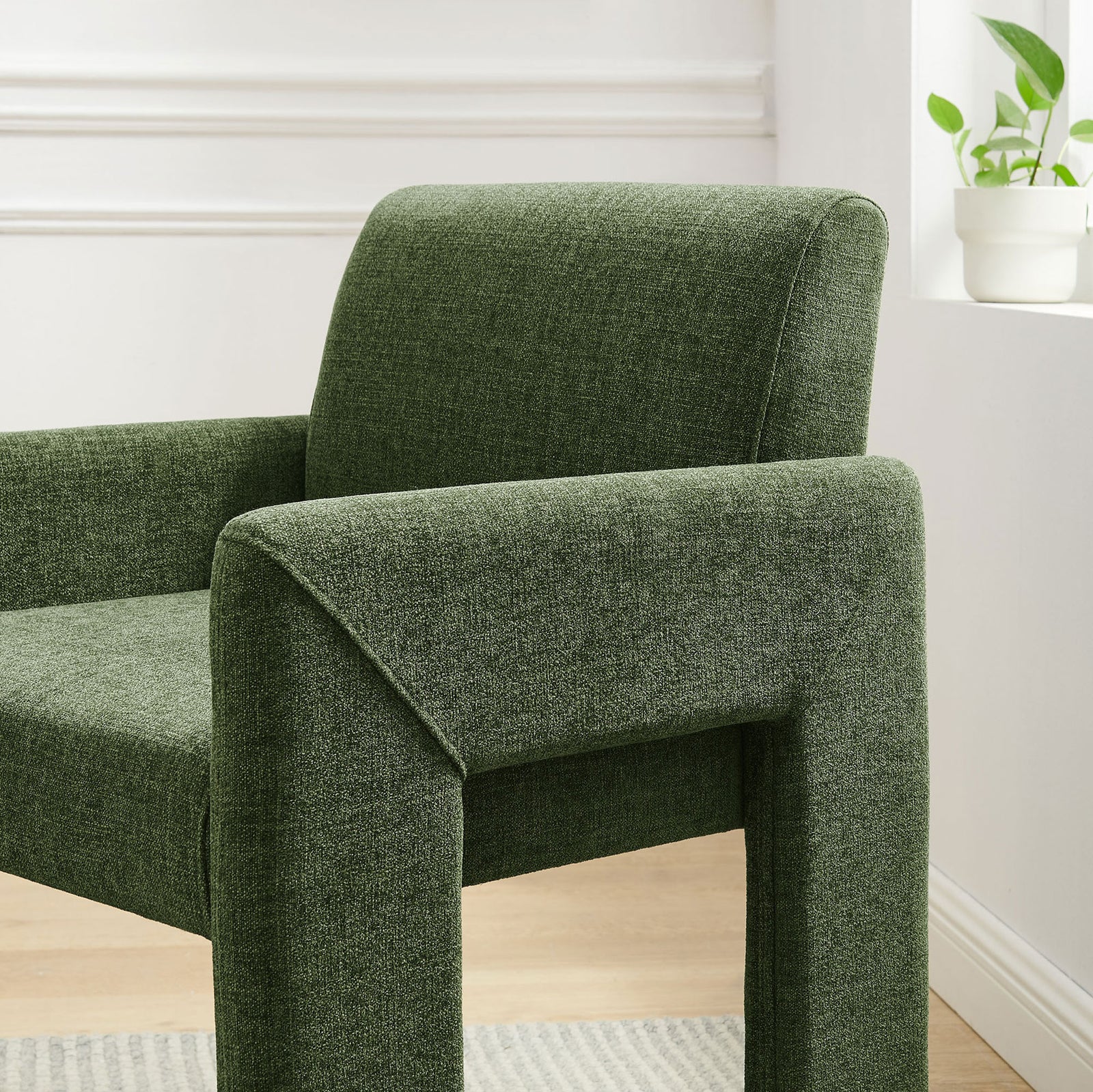 Green upholstered dining chair near a bright window, featuring a gently curved back and padded arm. || EEI-7524-FOL || detail_room