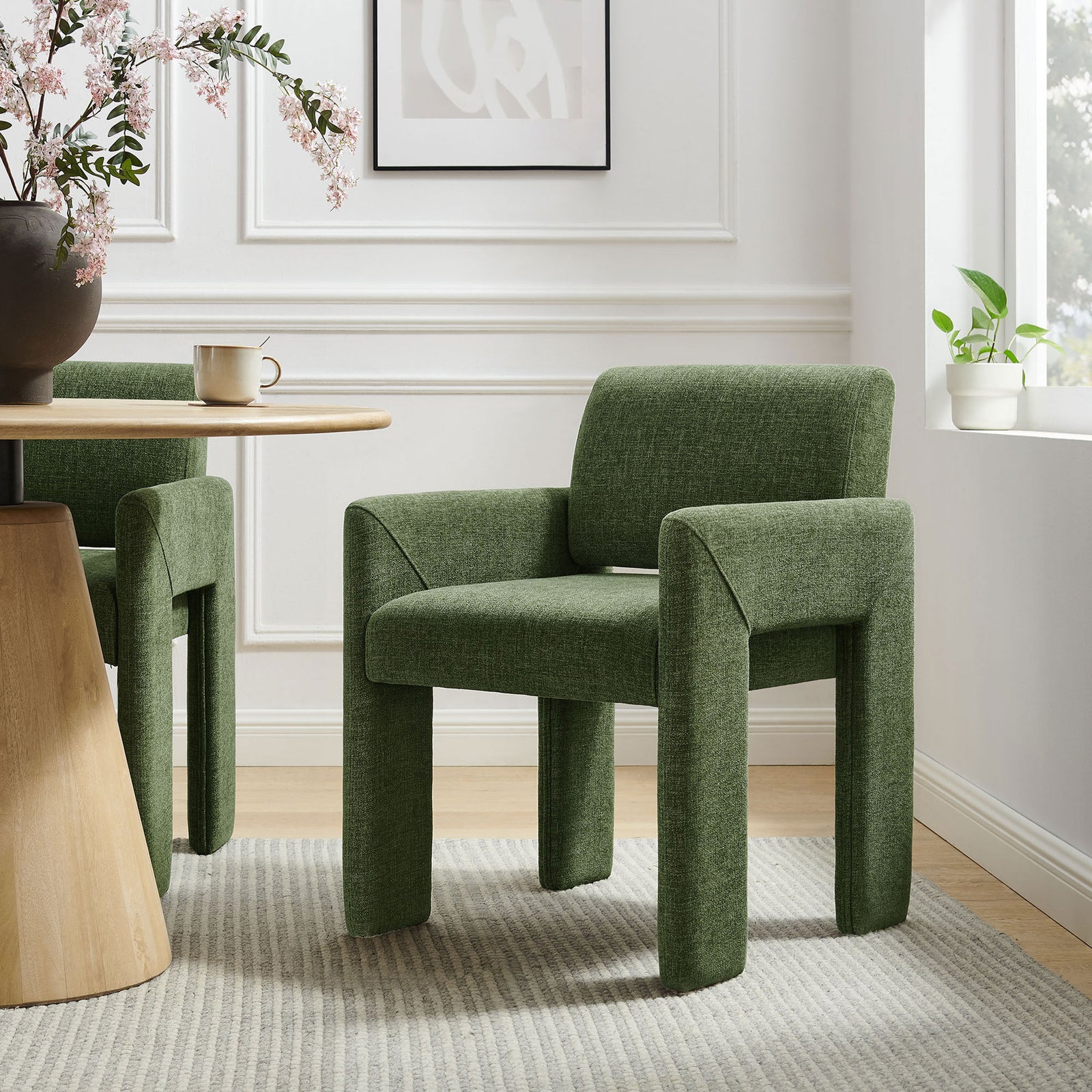 Pair of green upholstered dining chairs arranged around a light wood table in a modern dining room. || EEI-7524-FOL || front_angle_room