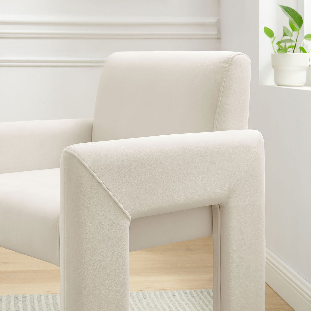 Alabaster velvet dining armchair brightening a modern nook with soft curves and clean architectural lines || EEI-7525-ALA || front_angle_room
