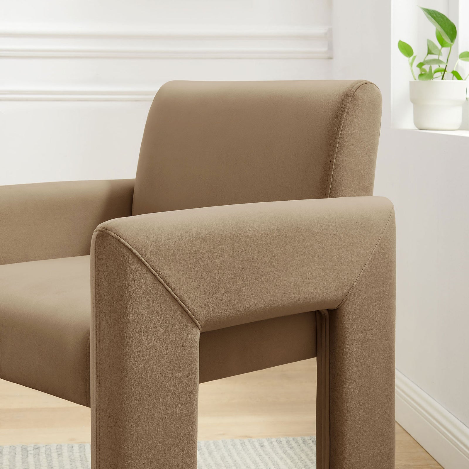 Taupe velvet dining armchair in a bright room, highlighting padded arms and stitching || EEI-7525-TAU || detail_room