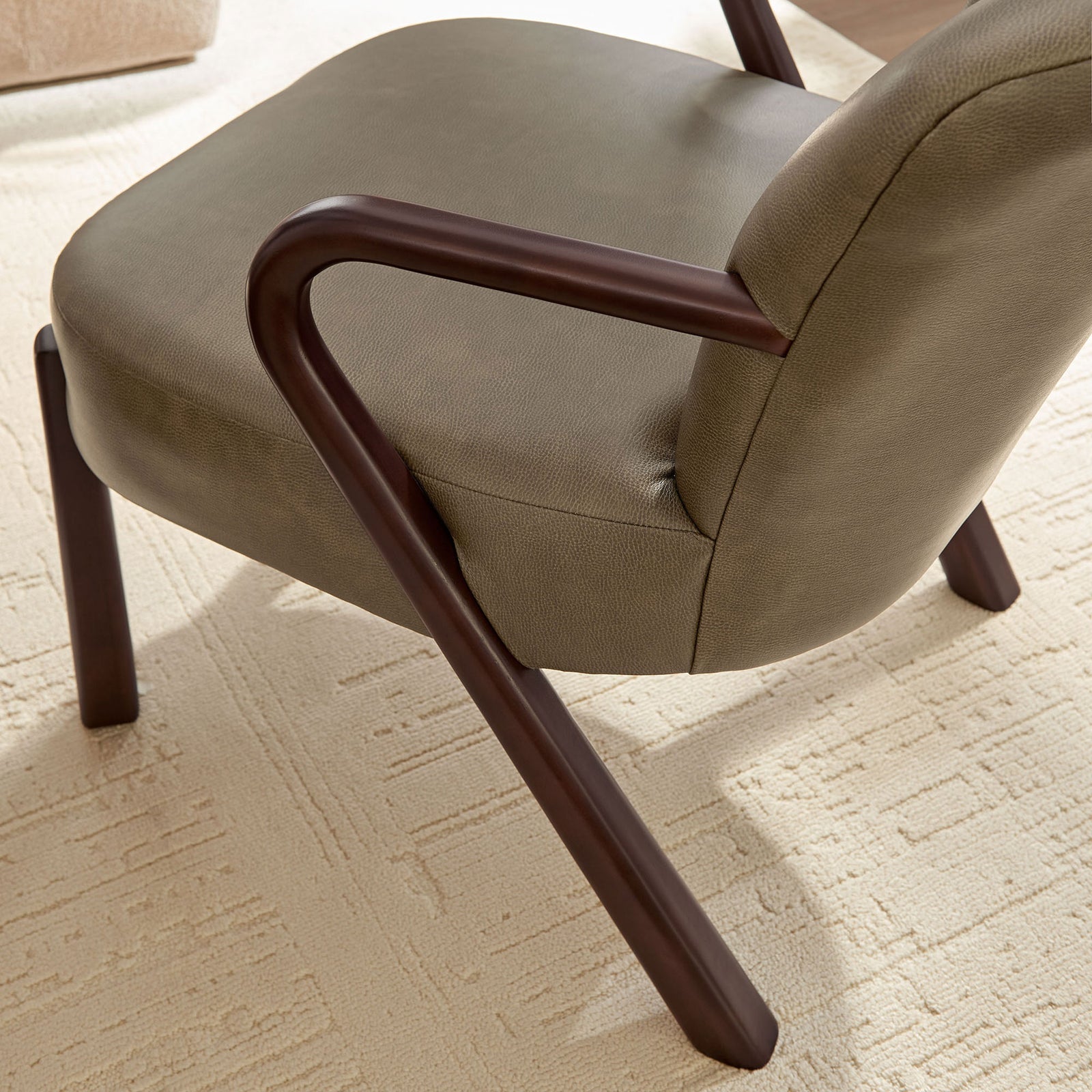 Textured mushroom faux leather pairs with a sculpted wood arm in a warm, modern living space || EEI-7529-MUS || detail_room
