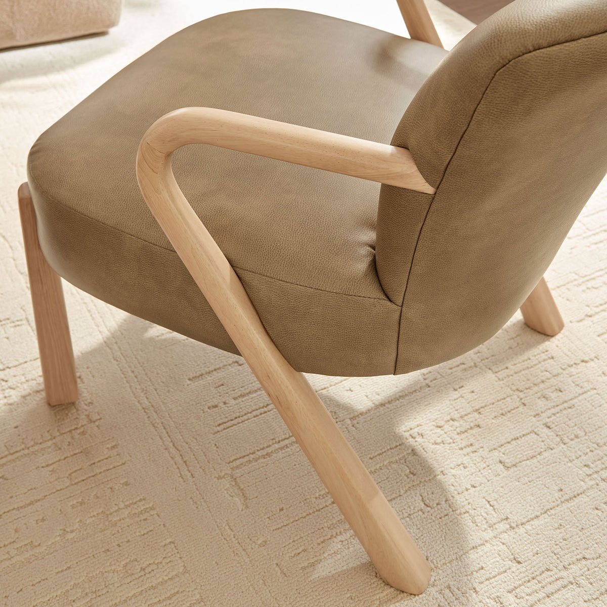 Light wood leg and arm detailing complement the textured vegan leather seat on a soft rug || EEI-7529-TST || leg_room