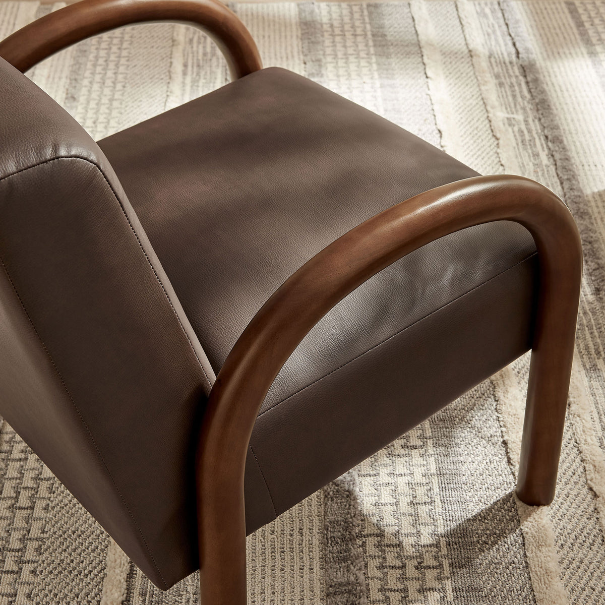 Rich espresso faux leather and rounded wood arms add texture and sculptural appeal to your space || EEI-7530-ESP || detail_room