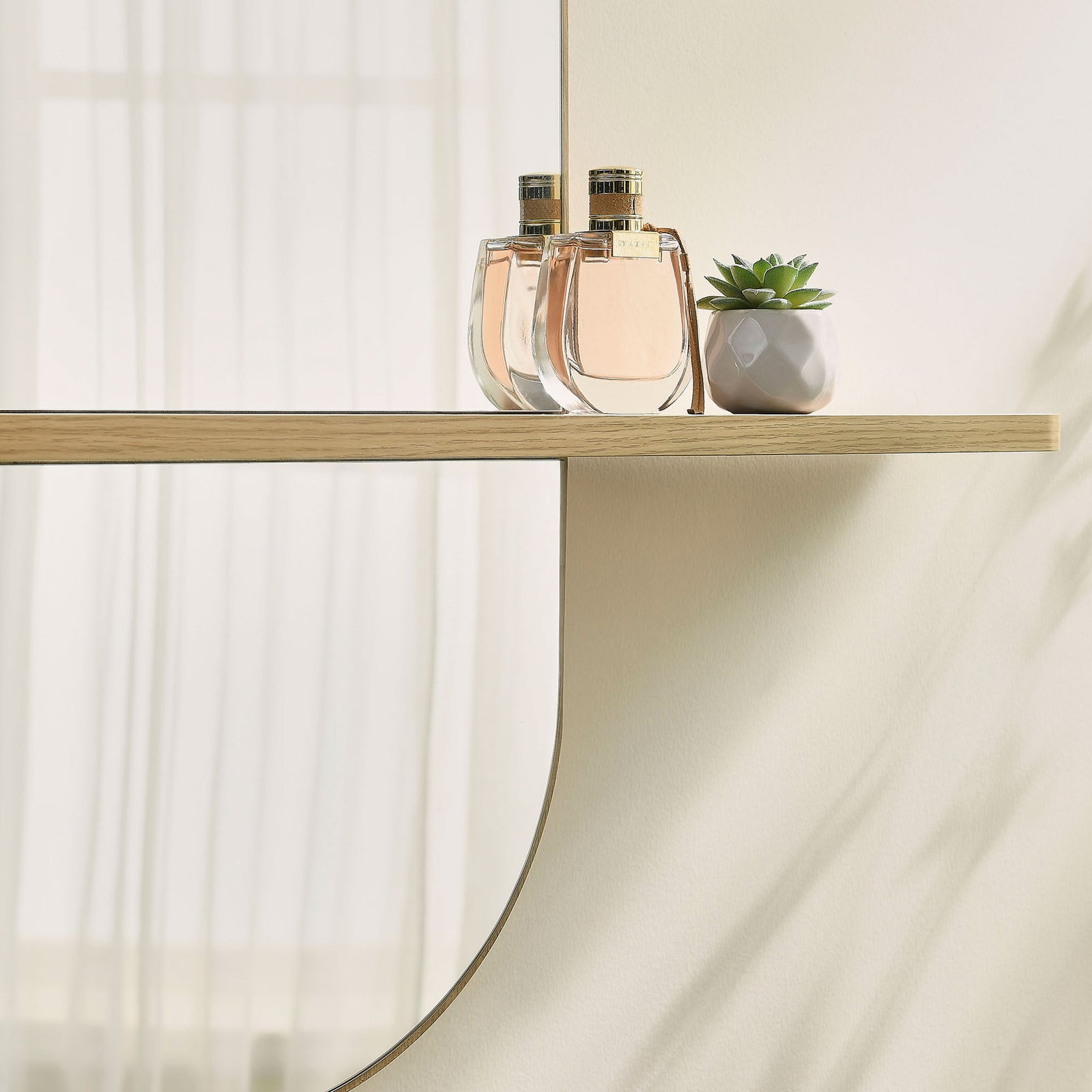 Large oak mirror shelf displaying perfume and a succulent against a softly lit wall. || EEI-7533-OAK || storage_room