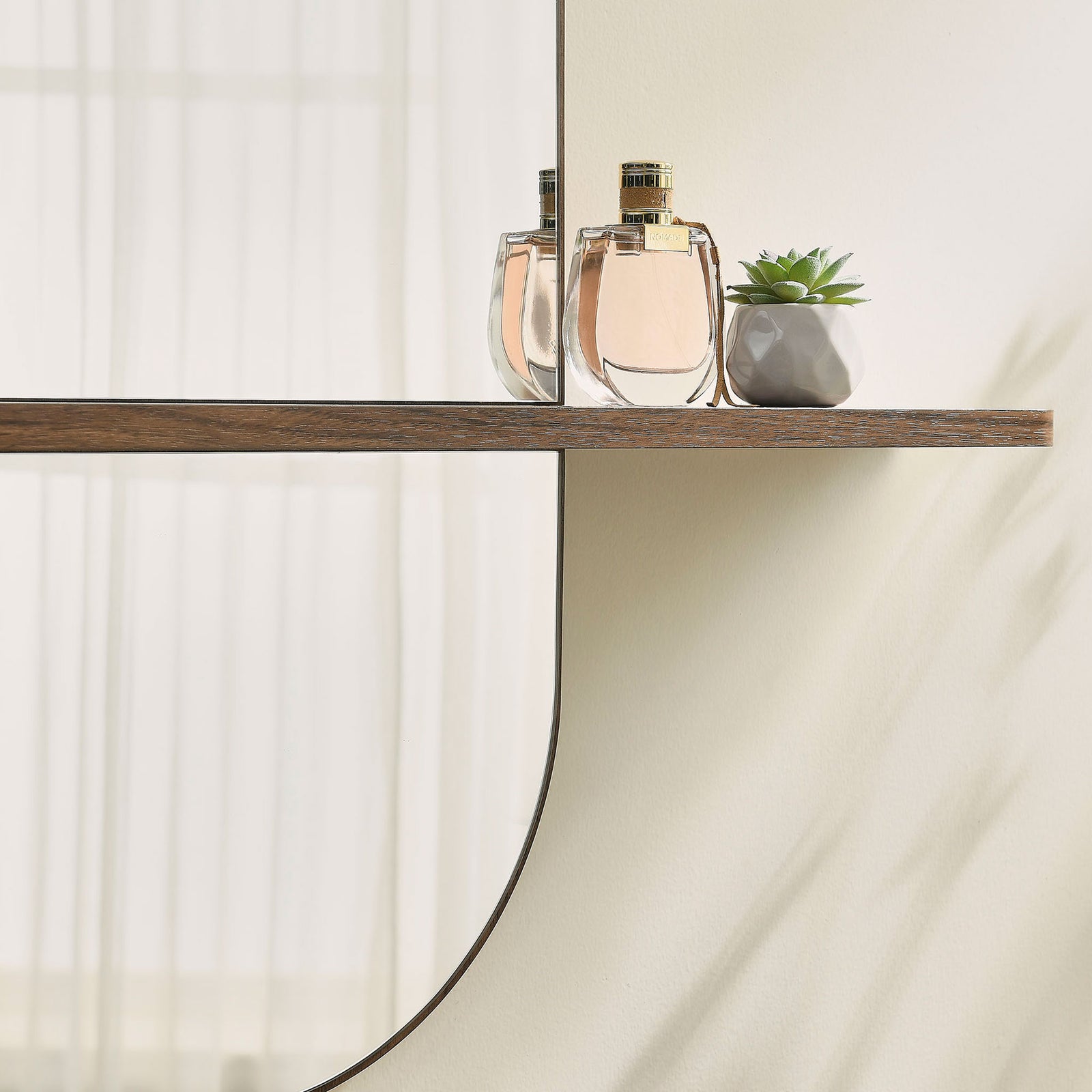Large walnut mirror shelf displaying fragrance bottles and a succulent on a soft neutral wall. || EEI-7533-WAL || storage_room