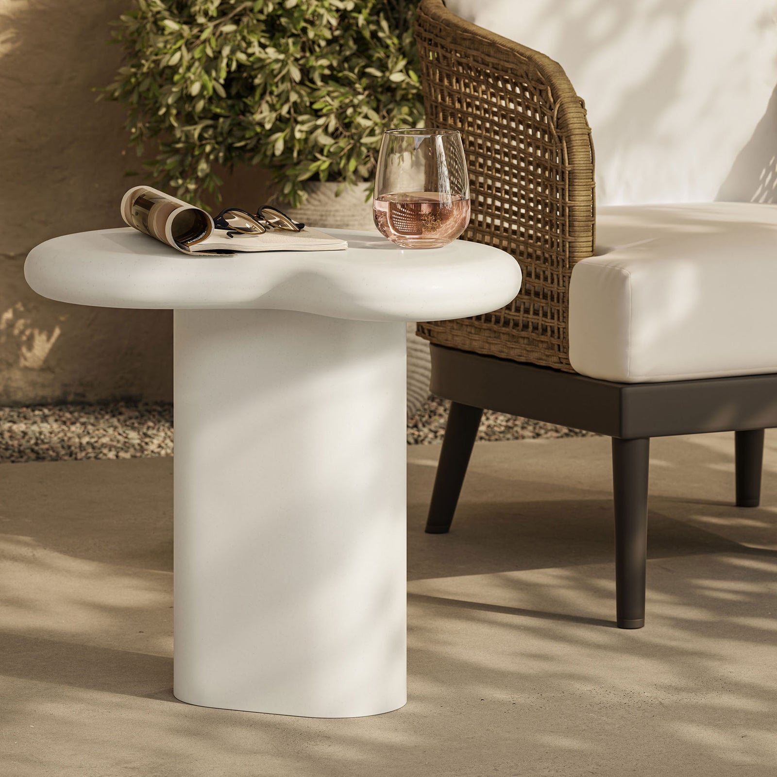 Kidney-shaped white side table on a bright patio beside cushioned seating, perfect for outdoor drinks || EEI-7535-WHI || front_angle_room