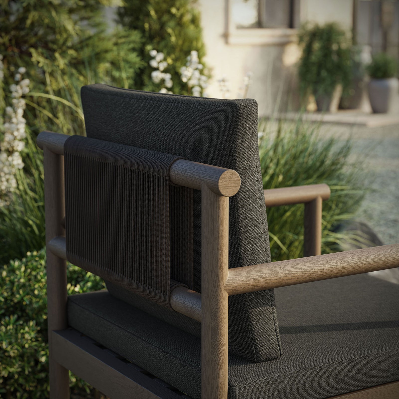 Close view of gray teak frame and rope backrest with dark cushions in outdoor setting. || EEI-7561-WGR-FLI || detail_room
