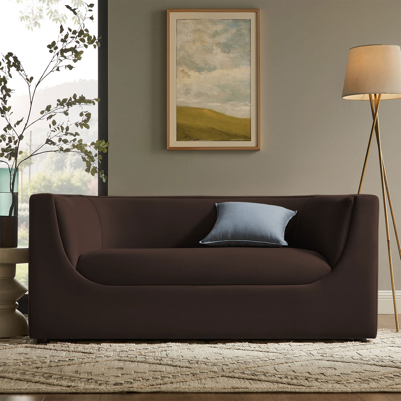 Chocolate brown curved-back loveseat anchors a modern living room with rug, floor lamp, and wall art || EEI-7565-CHB || front_room