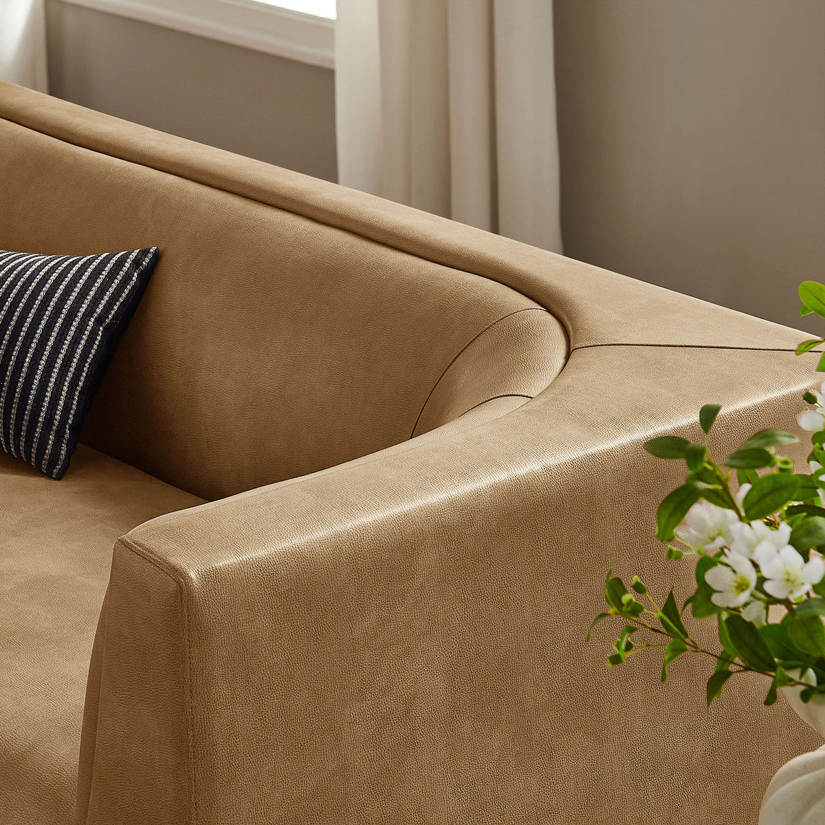 Styled corner of the sofa in a bright room, accented with a striped pillow and fresh greenery || EEI-7567-TST || detail_room