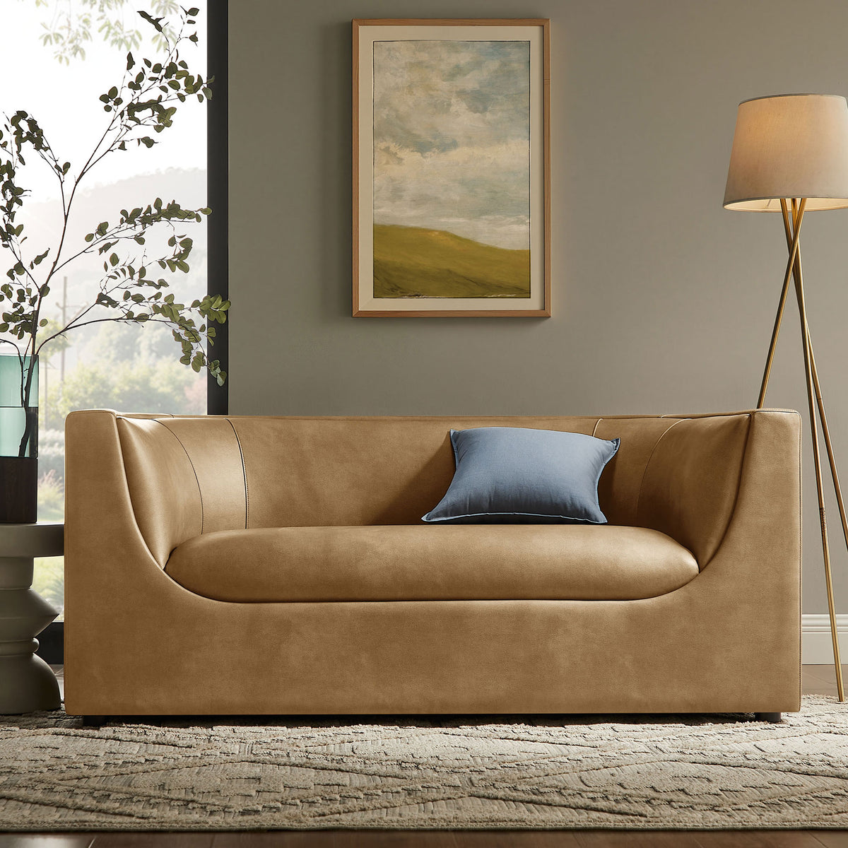 Toast vegan leather loveseat styled in a modern living room with blue accent pillow and floor lamp. || EEI-7568-TST || front_room