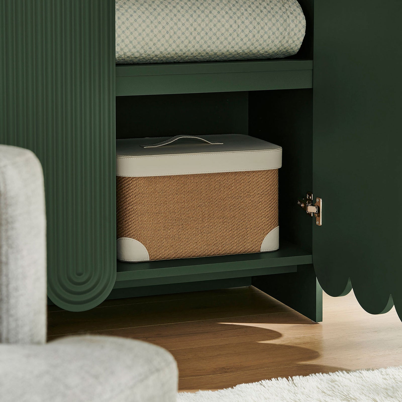 Styled interior of hunter green cabinet shelf holding a woven storage box and linens || EEI-7570-HGR || storage_open_room