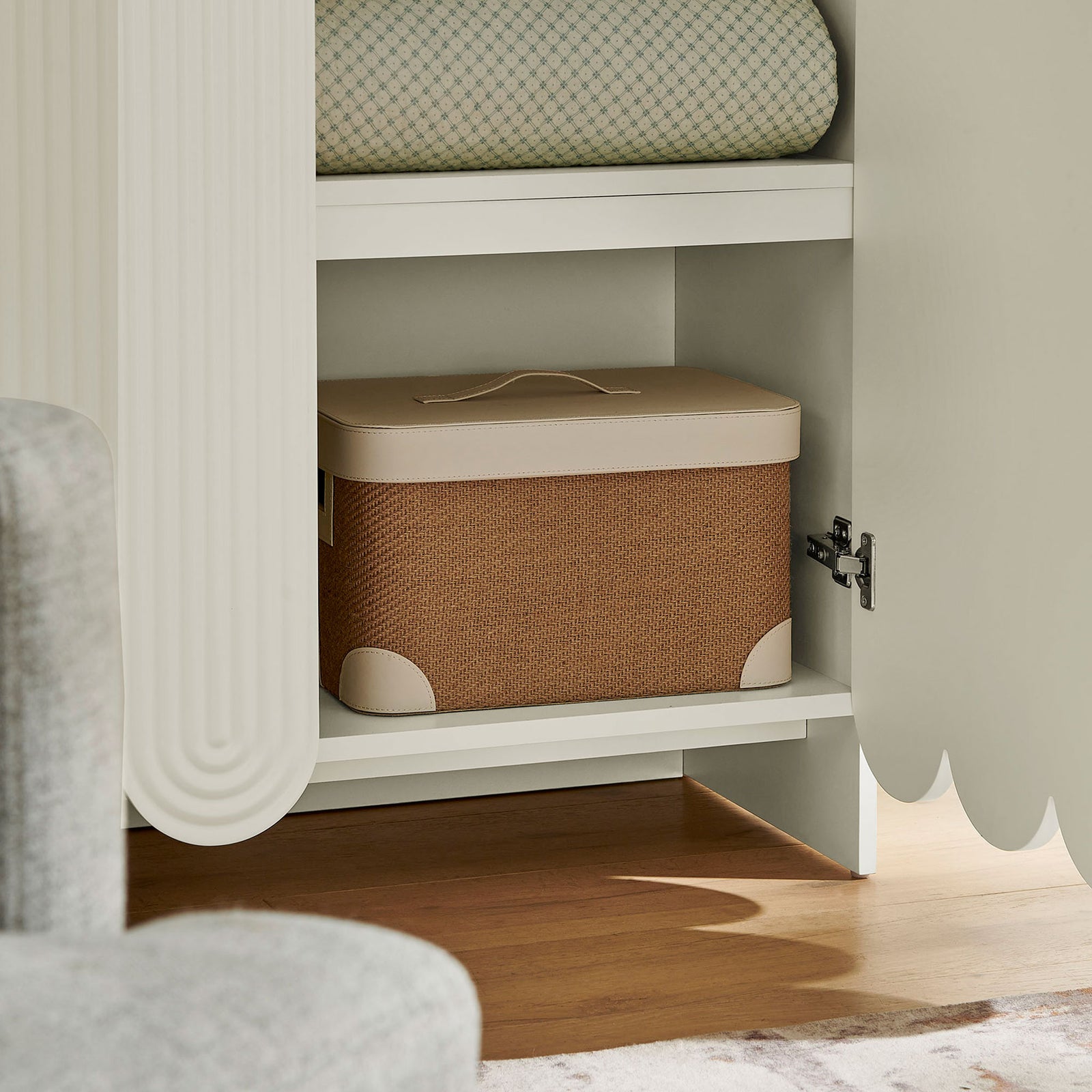 Styled interior of white cabinet shelf with woven storage box and folded textiles || EEI-7570-WHI || storage_open_room