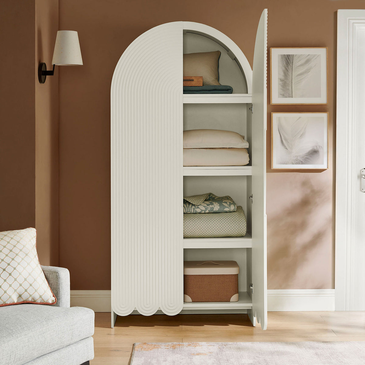 White arched cabinet with doors open, neatly storing blankets, pillows, and baskets || EEI-7570-WHI || front_open_room