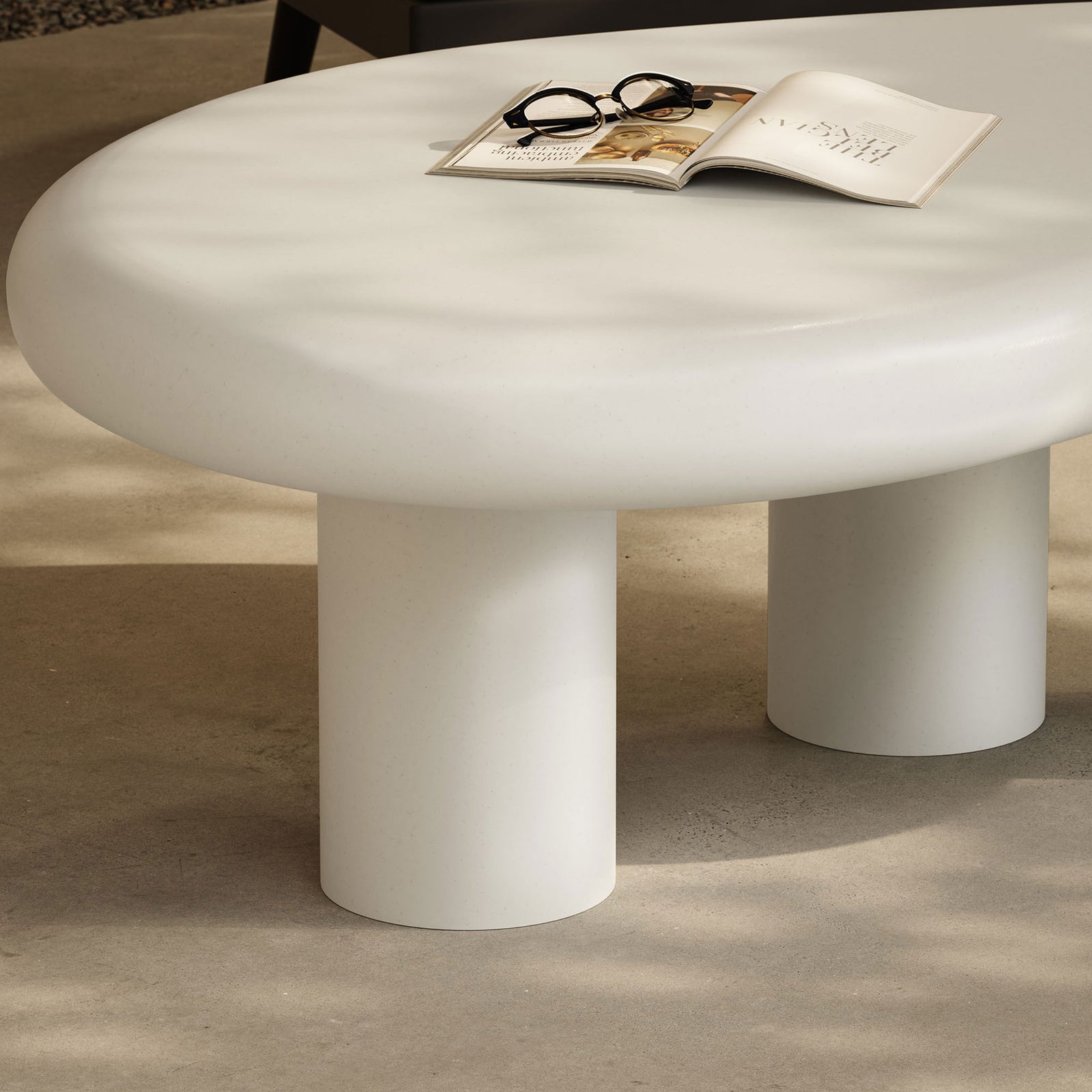 Sculptural white concrete base and smooth top bring artful simplicity to an outdoor seating nook || EEI-7571-WHI || detail_room