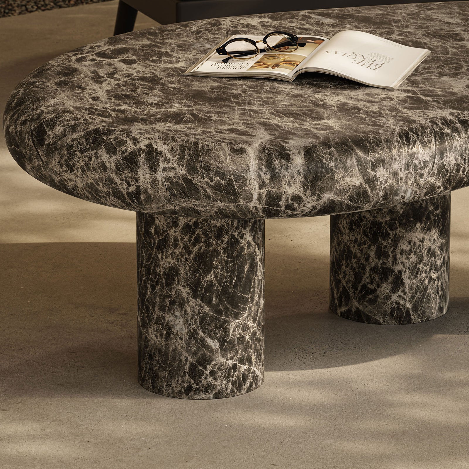 Dark faux marble coffee table brings organic curves and bold veining to an outdoor lounge setting || EEI-7573-EMP || detail_room