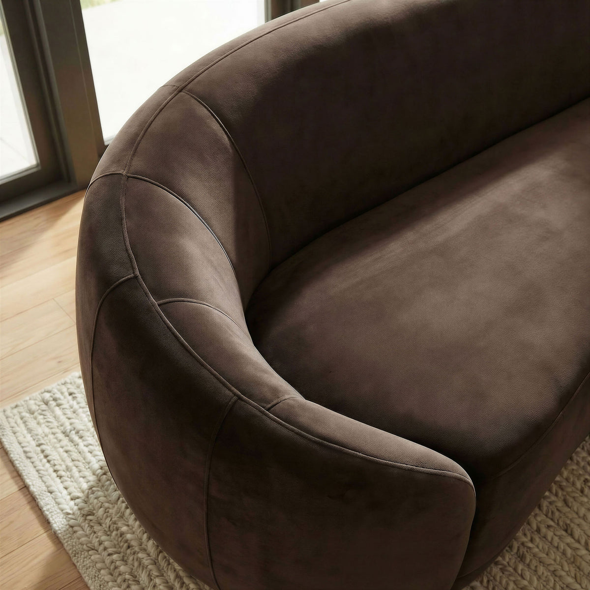 Sunlit chocolate brown velvet sofa arm highlighting soft texture and refined stitching || EEI-7581-CHB || detail_room