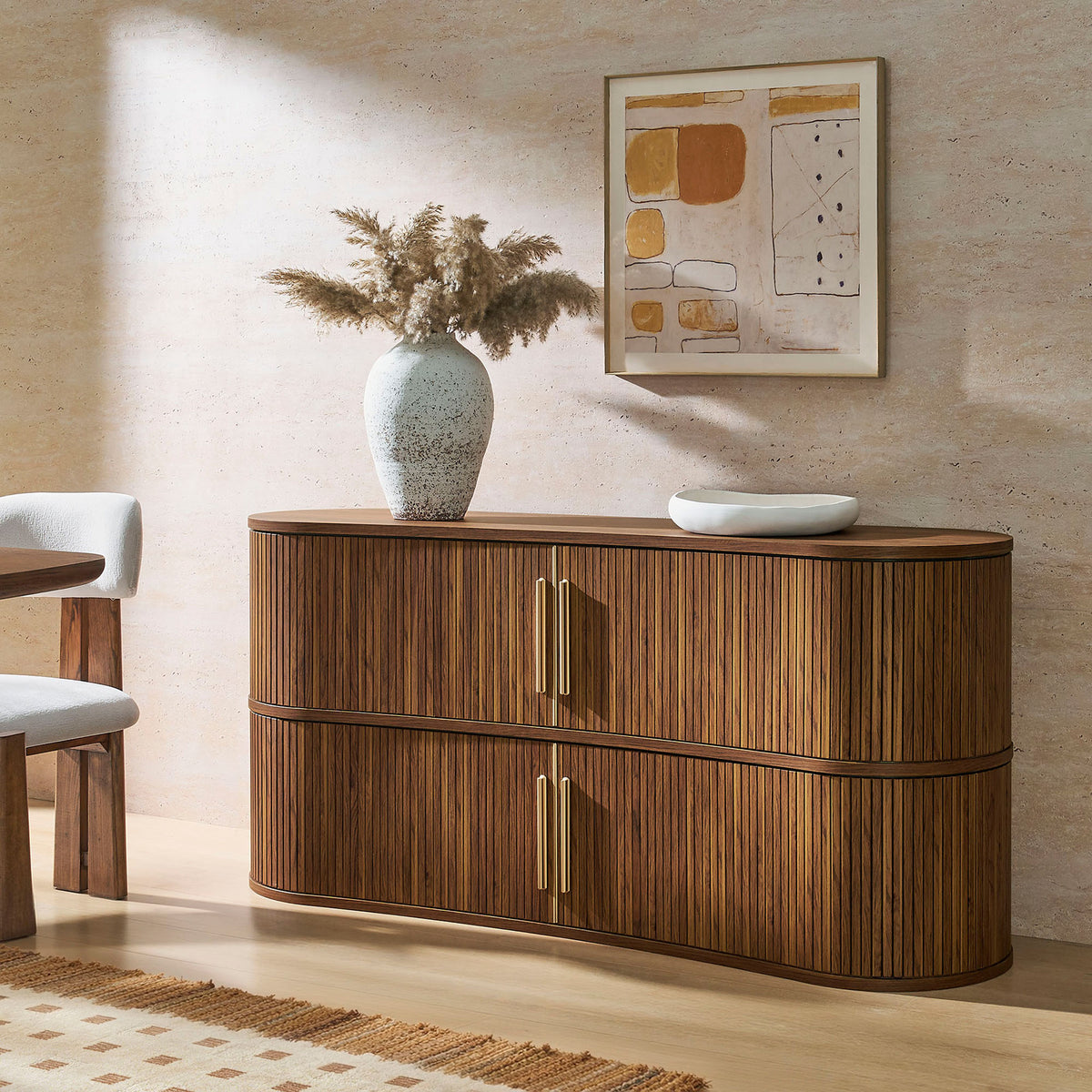 Curved walnut sideboard styled with decor, adding warm texture and modern elegance to the dining space || EEI-7583-WAL || front_angle_room