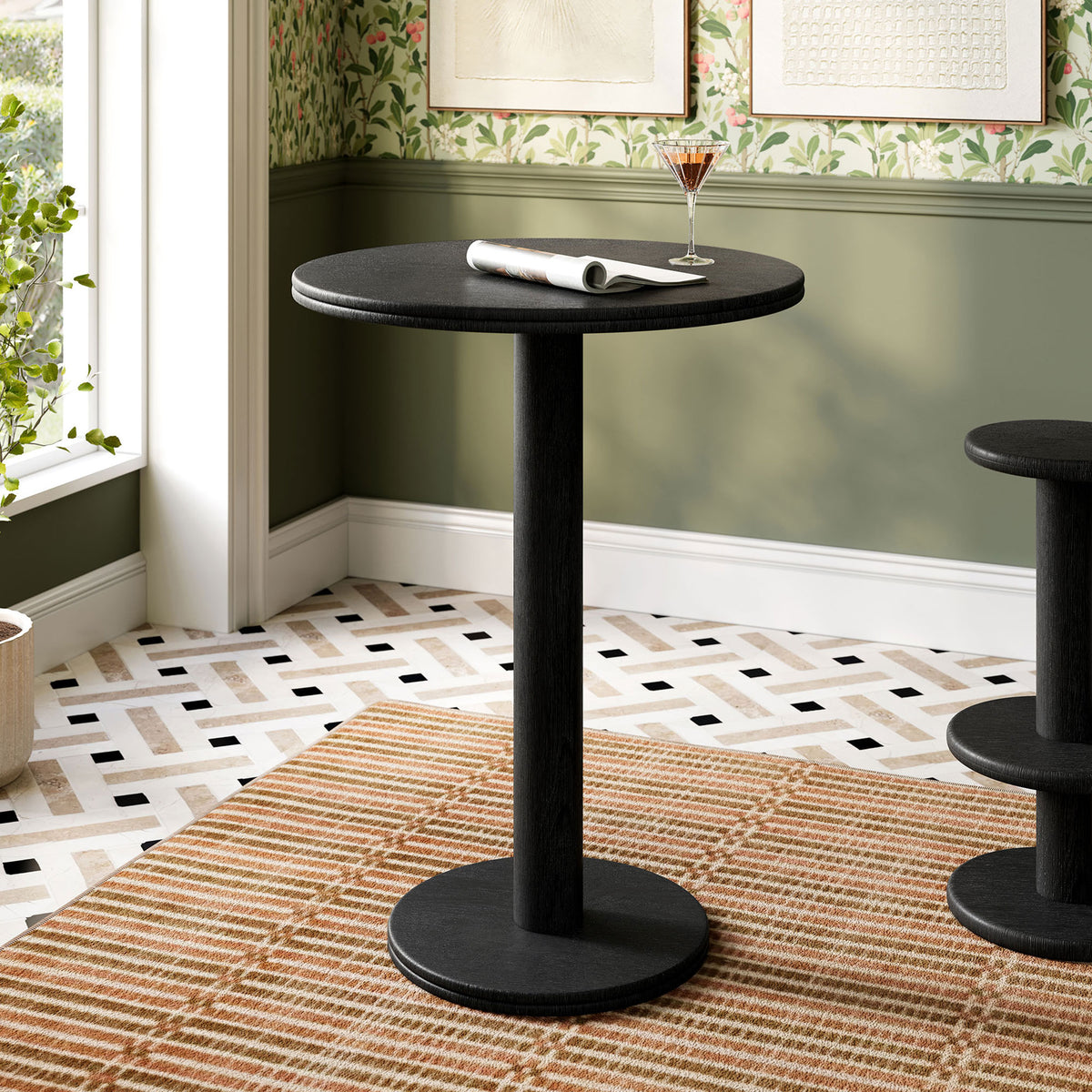 Black indoor outdoor bar table with clean pedestal base bringing modern warmth to dining nook. || EEI-7585-BLK || front_angle_room