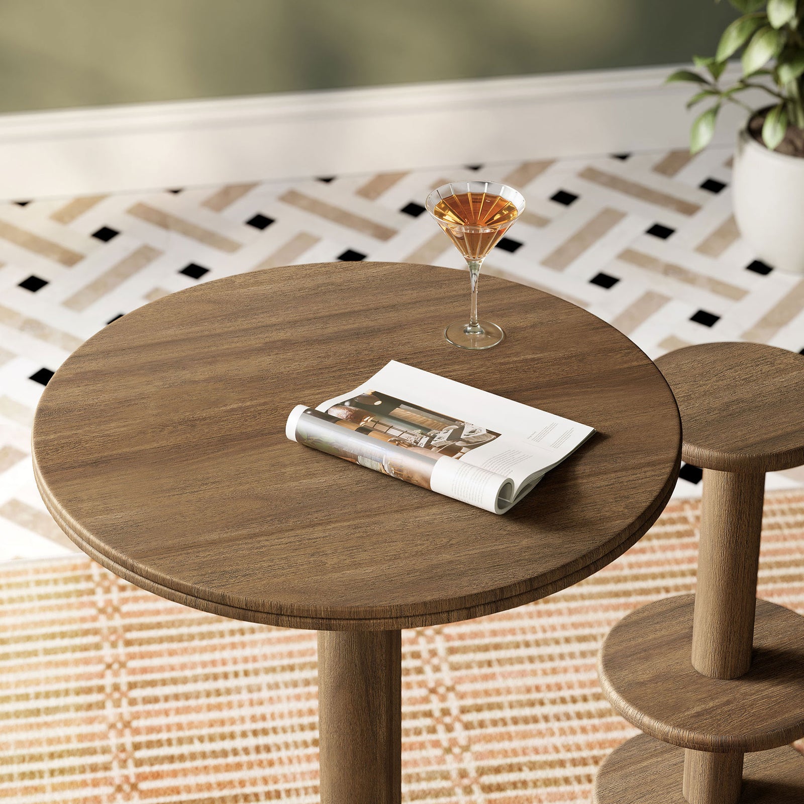 Cocoa brown round bar table styled with cocktail and magazine, adding relaxed charm over patterned rug. || EEI-7585-COA || detail_room