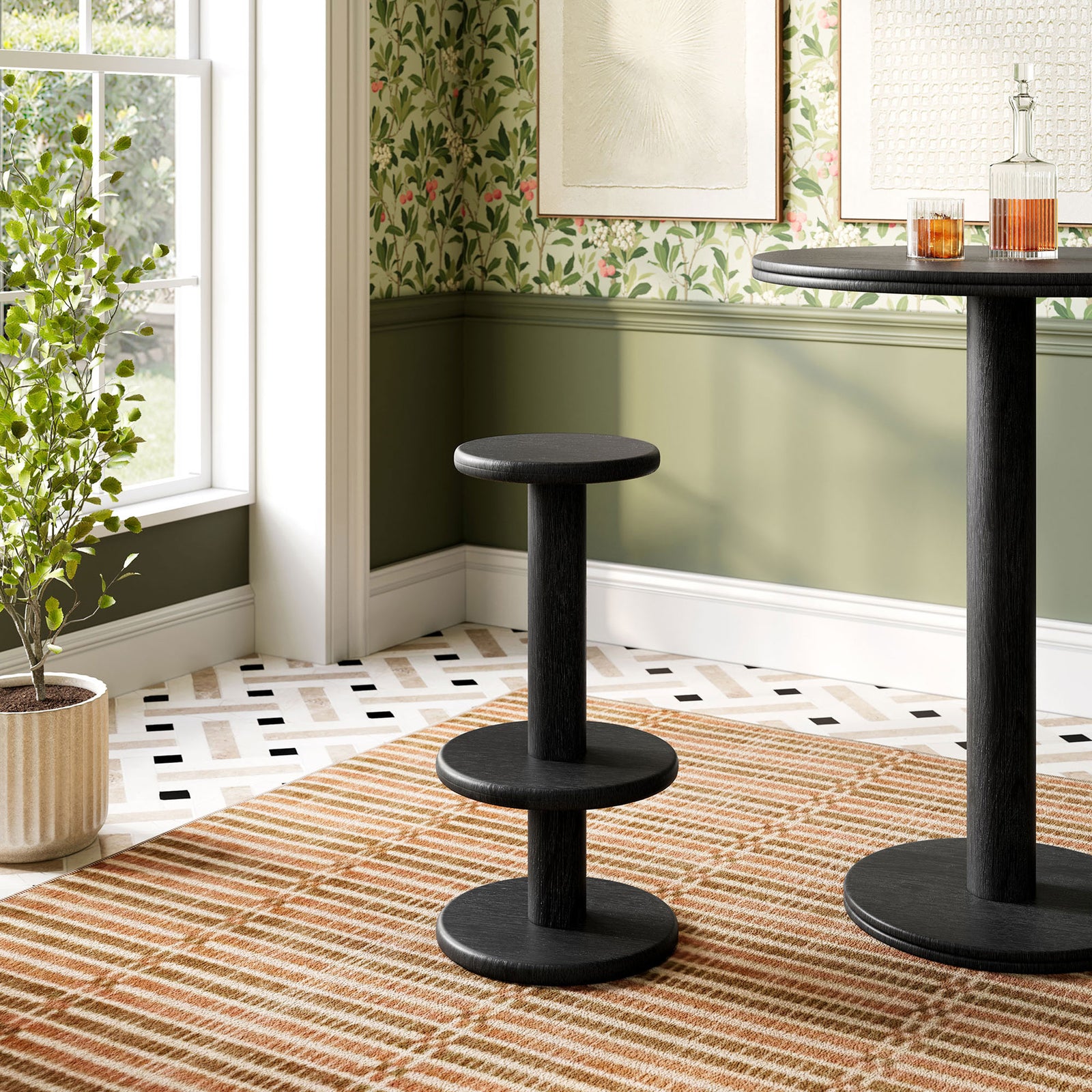 Black acacia bar stool beside a matching pedestal bar table in a bright dining nook || EEI-7586-BLK || front_angle_room