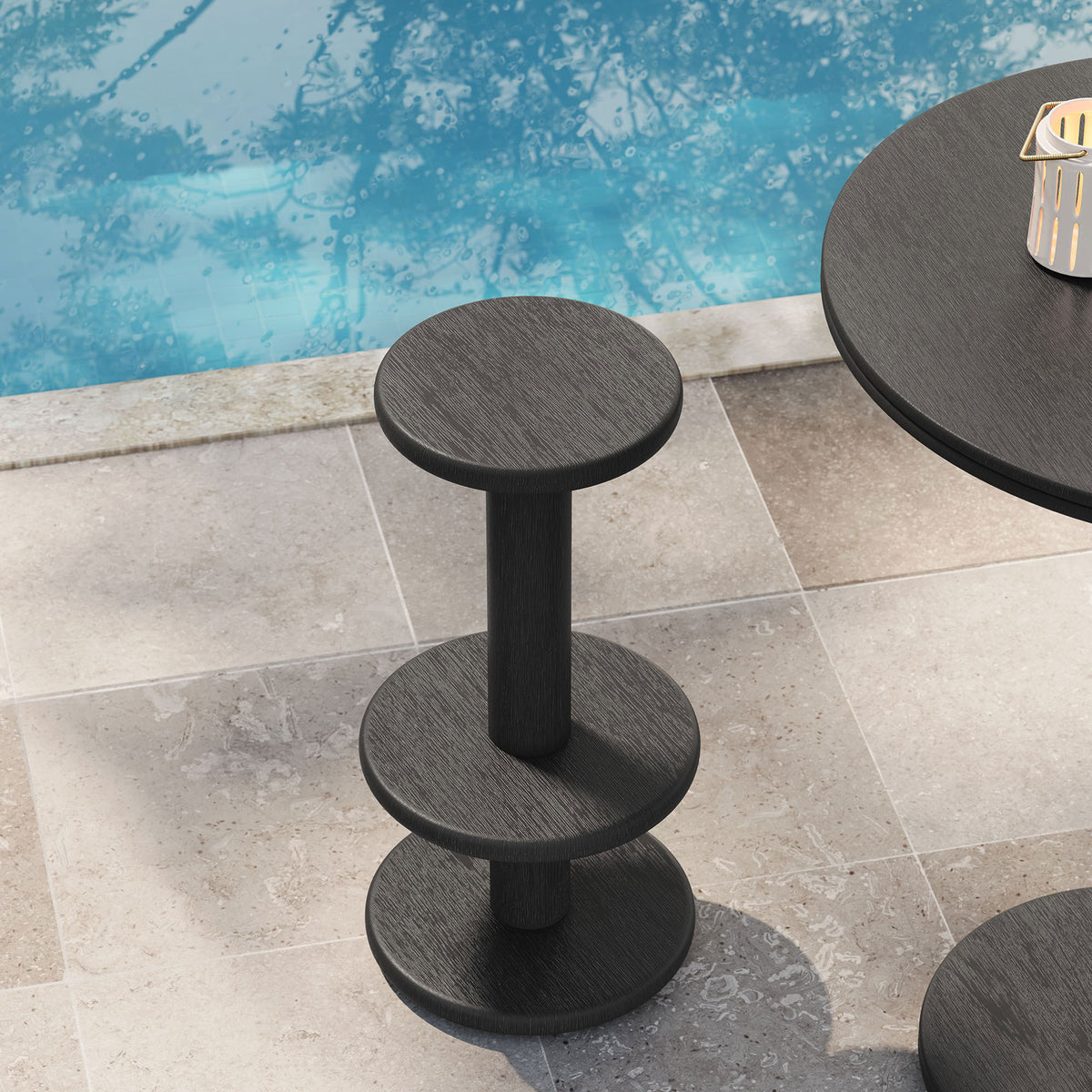 Black acacia bar stool on a stone patio beside a swimming pool for outdoor entertaining || EEI-7586-BLK || front_angle_room