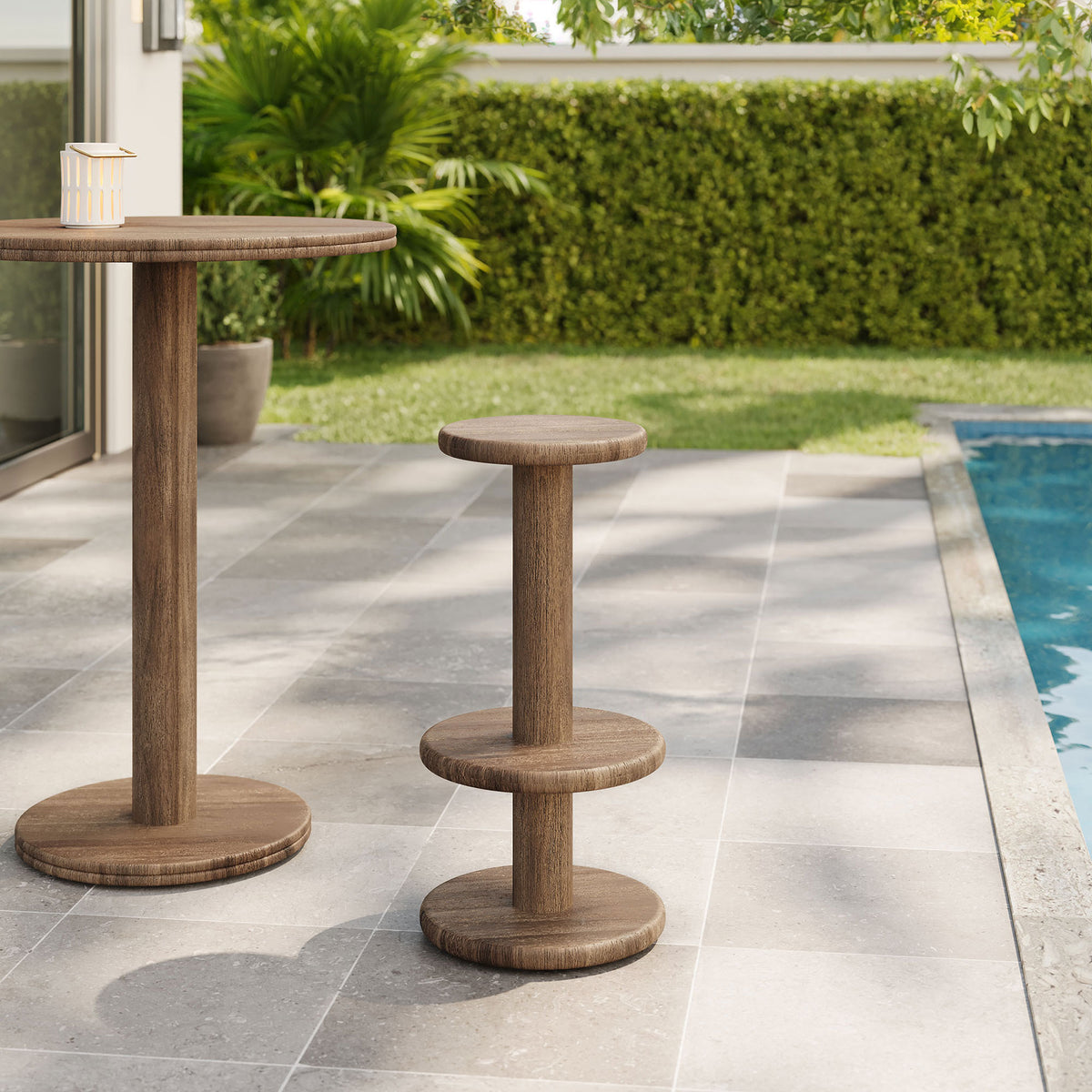 Cocoa brown acacia bar stool and pedestal bar table on a poolside patio with lush greenery || EEI-7586-COA || front_angle_room