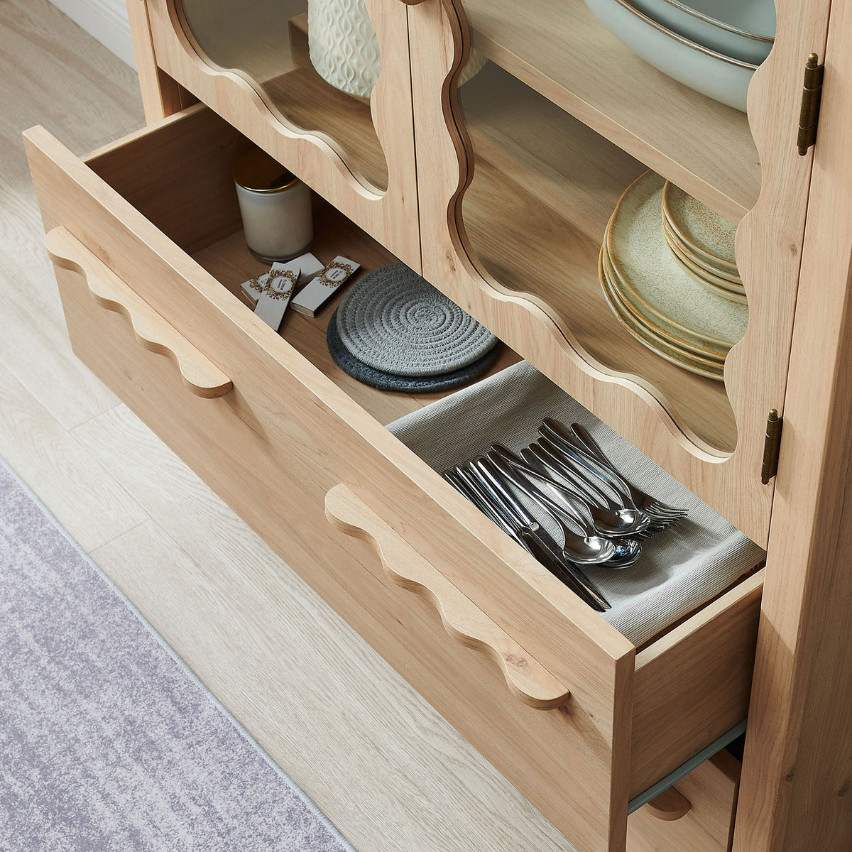 Open drawers neatly organized with flatware and linens inside the light oak pantry cabinet || EEI-7589-LOA || storage_open_room