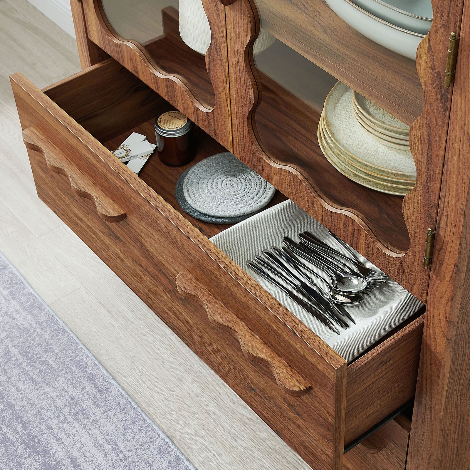 Open drawers arranged with flatware and linens inside the walnut kitchen cabinet || EEI-7589-WAL || storage_open_room