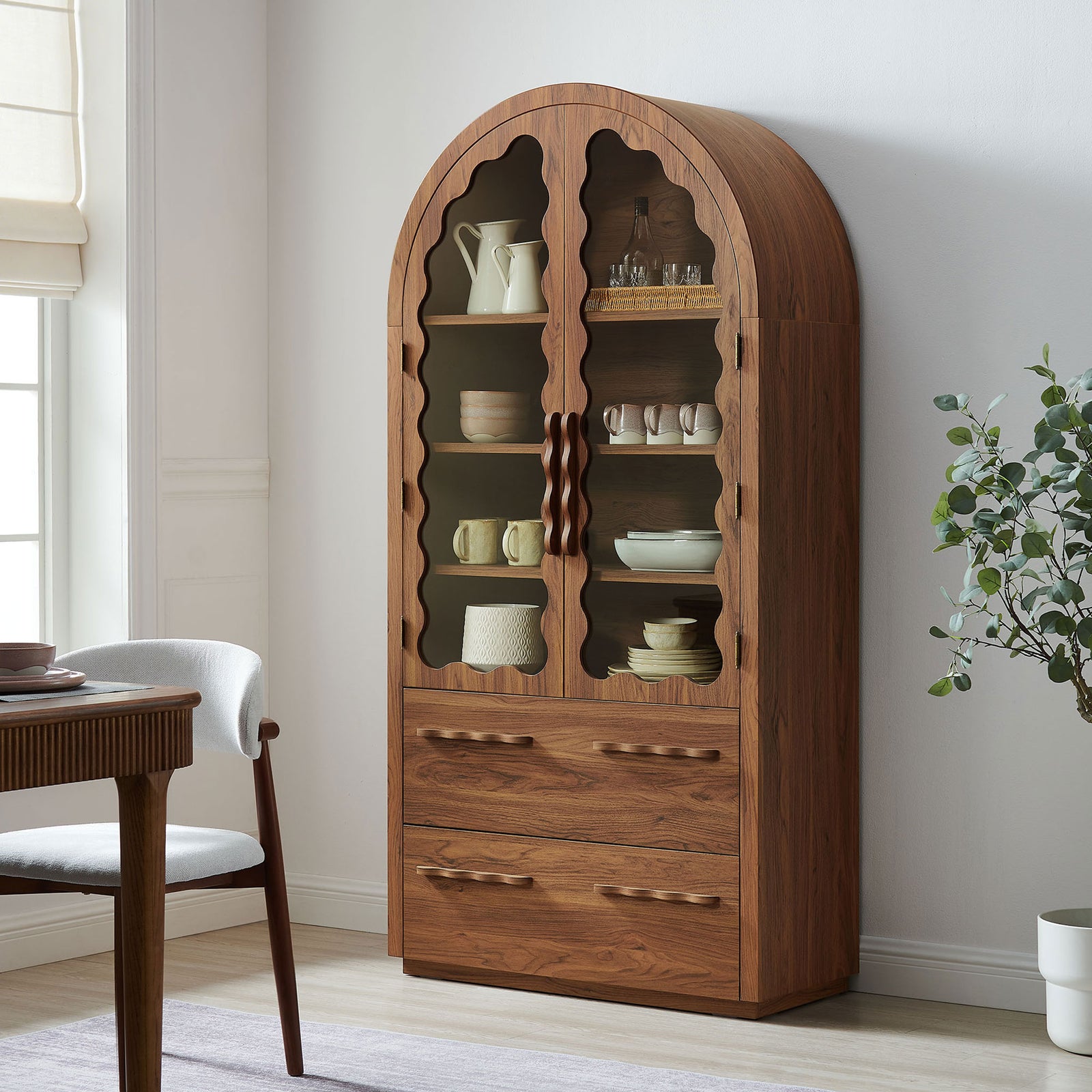 Walnut arch cabinet styled in a dining room with dishes and decor on display || EEI-7589-WAL || front_angle_room
