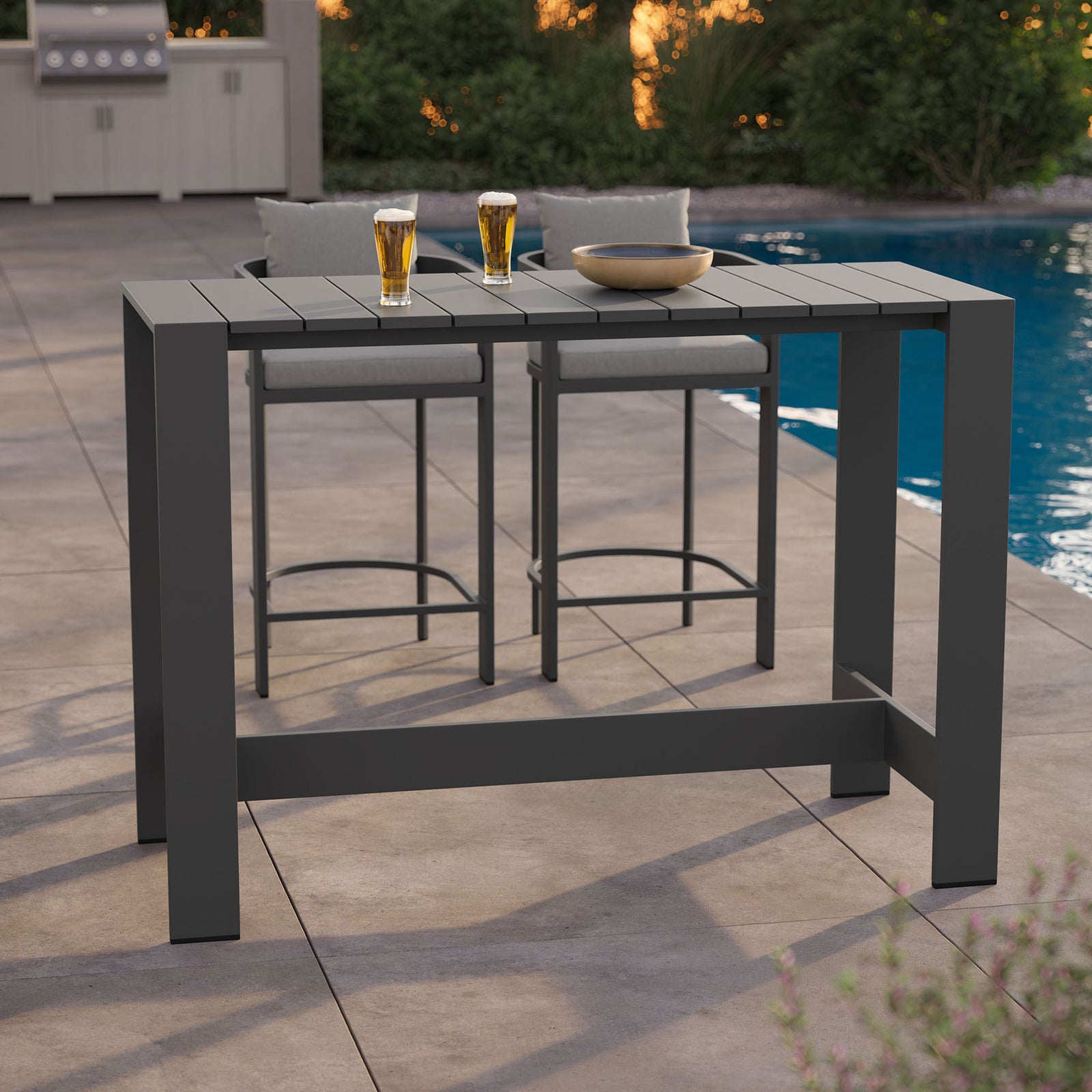 Gray aluminum bar table on patio styled with stools, drinks, and a bowl for casual outdoor gatherings || EEI-7593-GRY || front_angle_room