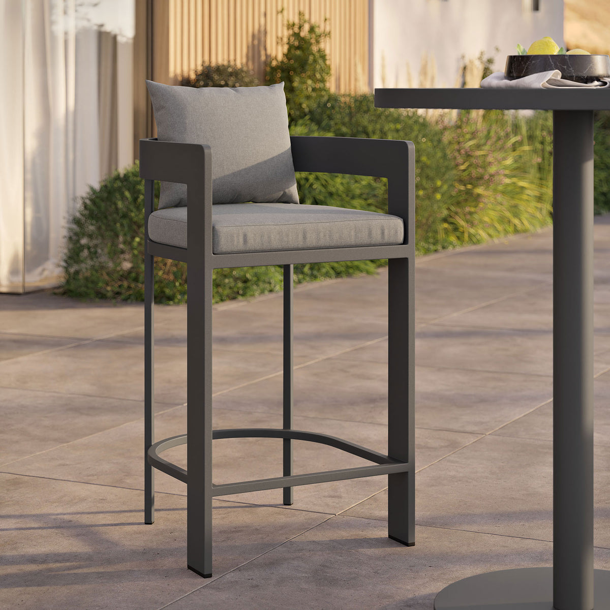Tahoe bar chair with gray cushions styled at an outdoor bar table for relaxed alfresco gatherings. || EEI-7595-GRY || front_angle_room
