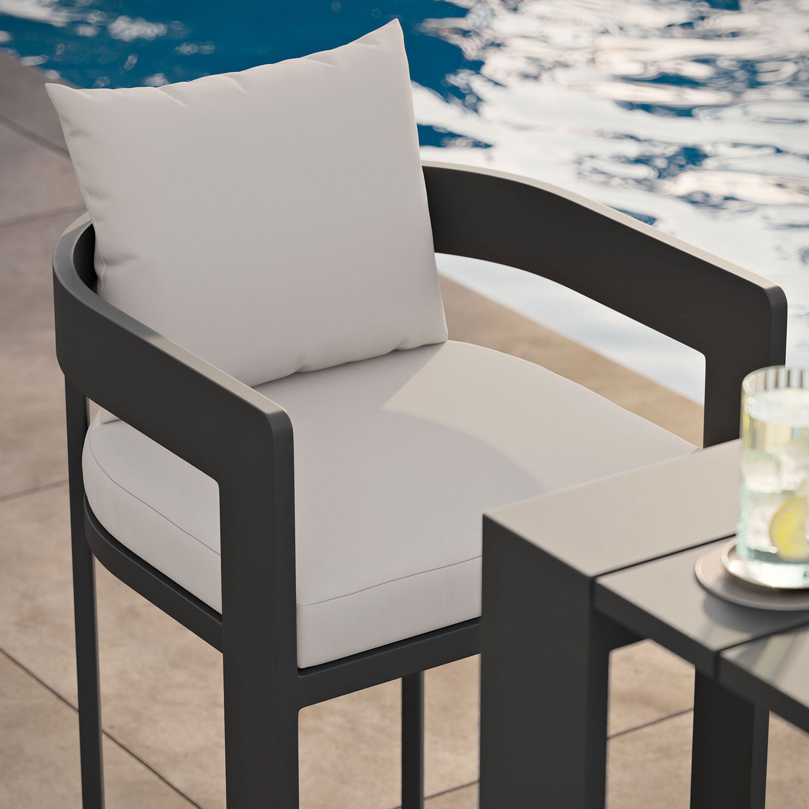 Tahoe bar chair beside the pool, highlighting white cushions and dark aluminum frame at the bar. || EEI-7595-WHI || detail_room