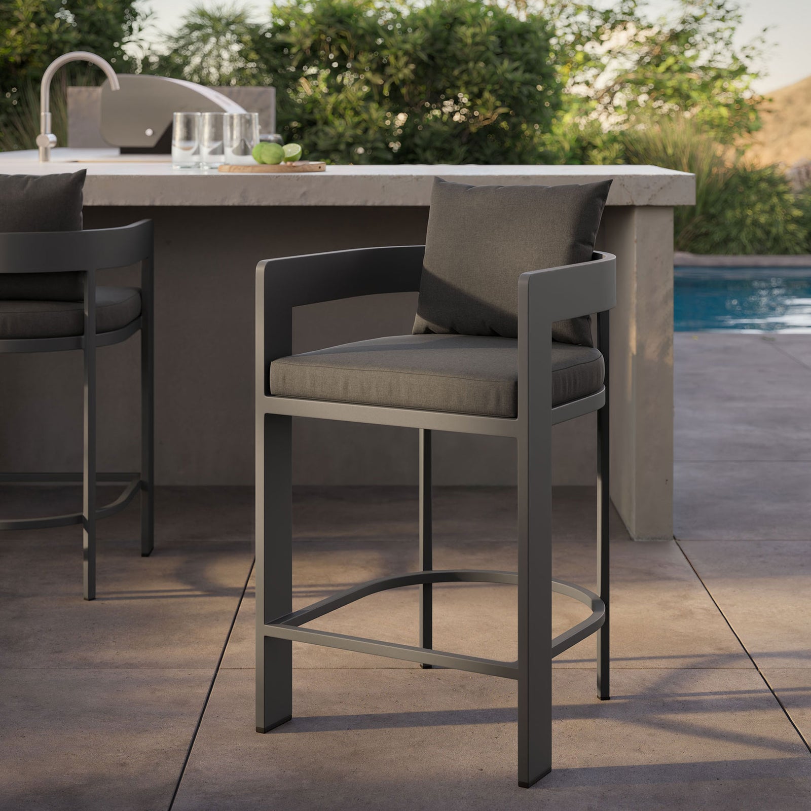 Tahoe counter stool beside the pool, highlighting charcoal cushions and matte aluminum frame at the bar. || EEI-7596-CHA || detail_room