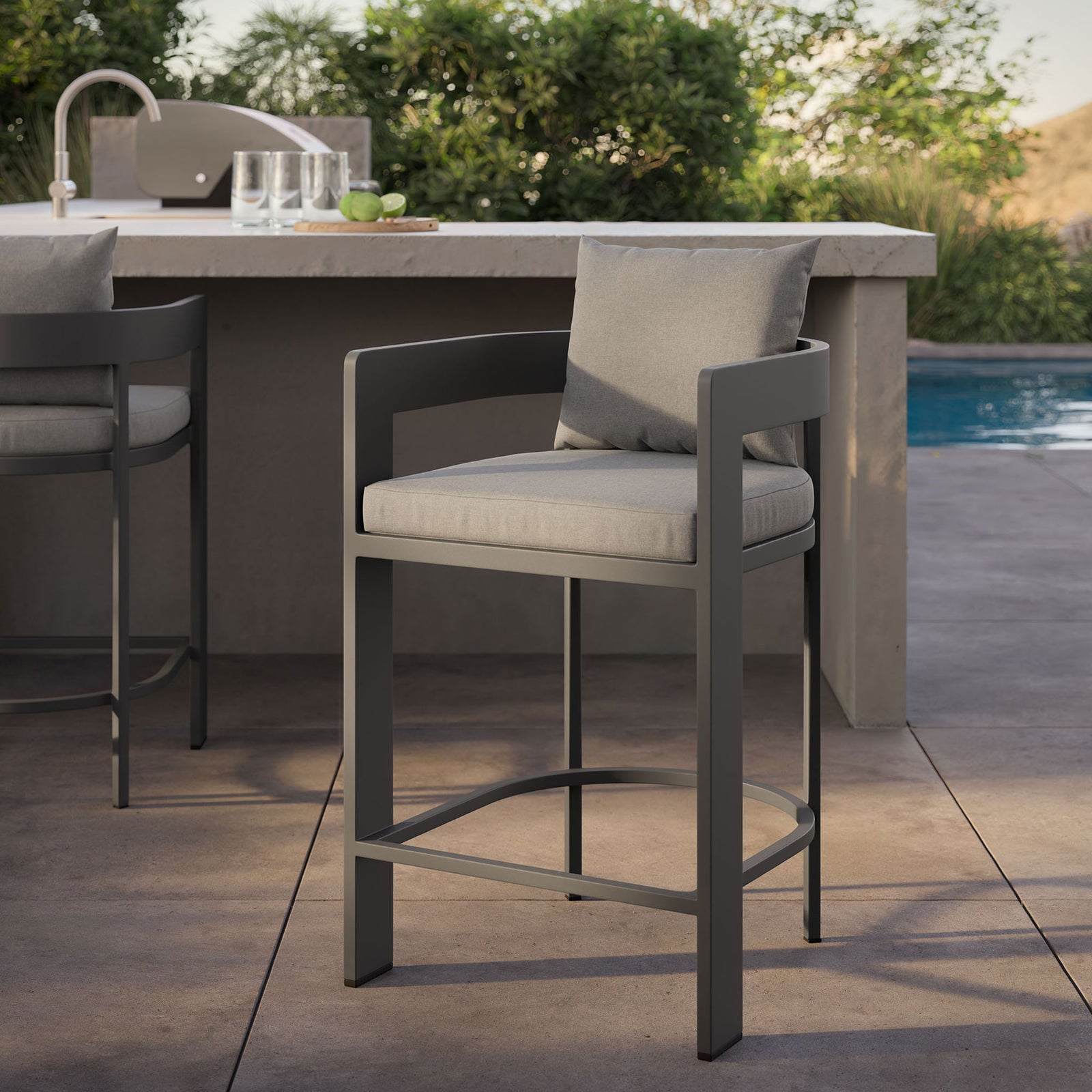 Outdoor scene with Tahoe counter stool, emphasizing gray cushions and dark aluminum frame beside the pool. || EEI-7596-GRY || detail_room