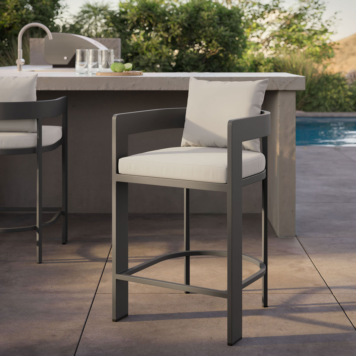 Tahoe counter stool by the pool, drawing attention to the white cushions and dark aluminum frame at the counter. || EEI-7596-WHI || detail_room