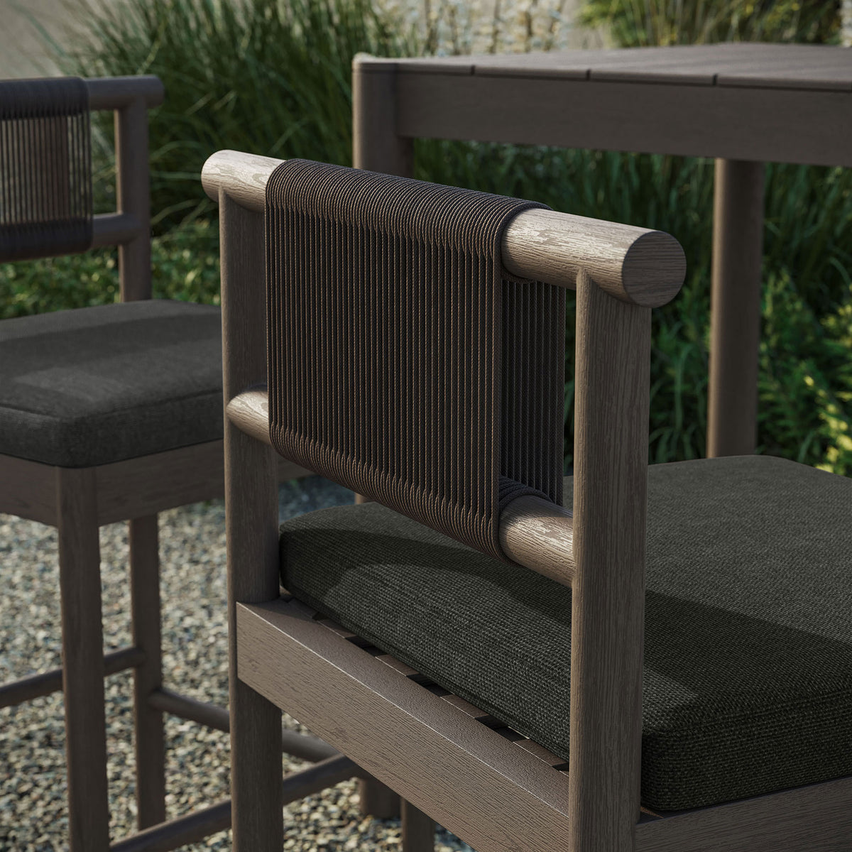 Outdoor close-up of weathered gray bar stool rope back and cushion beside a bar table || EEI-7626-WGR-FLI || detail_room