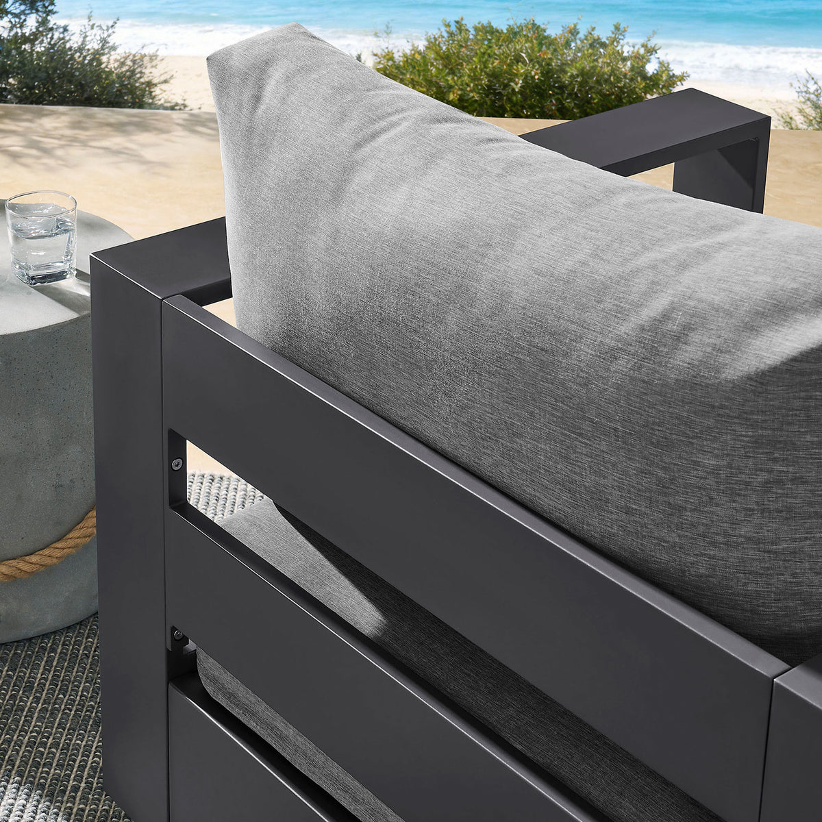 Outdoor detail of Tahoe chair back cushion framed by charcoal slatted aluminum backrest || EEI-7728-GRY-GRY || detail_room