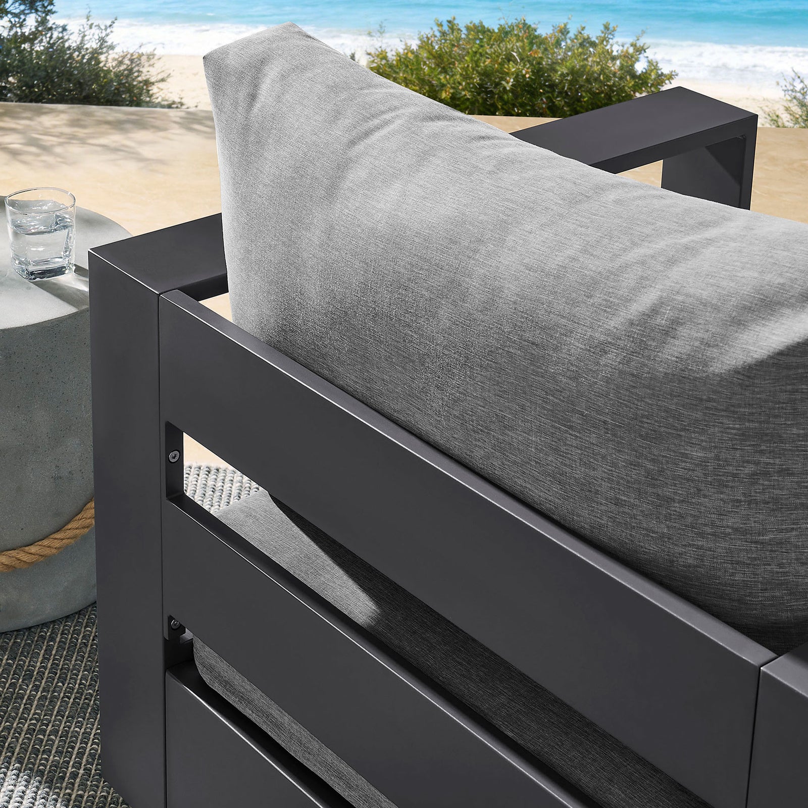 Outdoor detail of Tahoe chair back cushion framed by charcoal slatted aluminum backrest || EEI-7728-GRY-GRY || detail_room