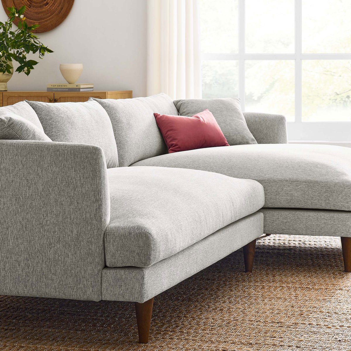 Cozy light gray sectional with chaise styled in a bright living room with warm wood tones and accent pillow || EEI-6612-HLG || front_angle_room