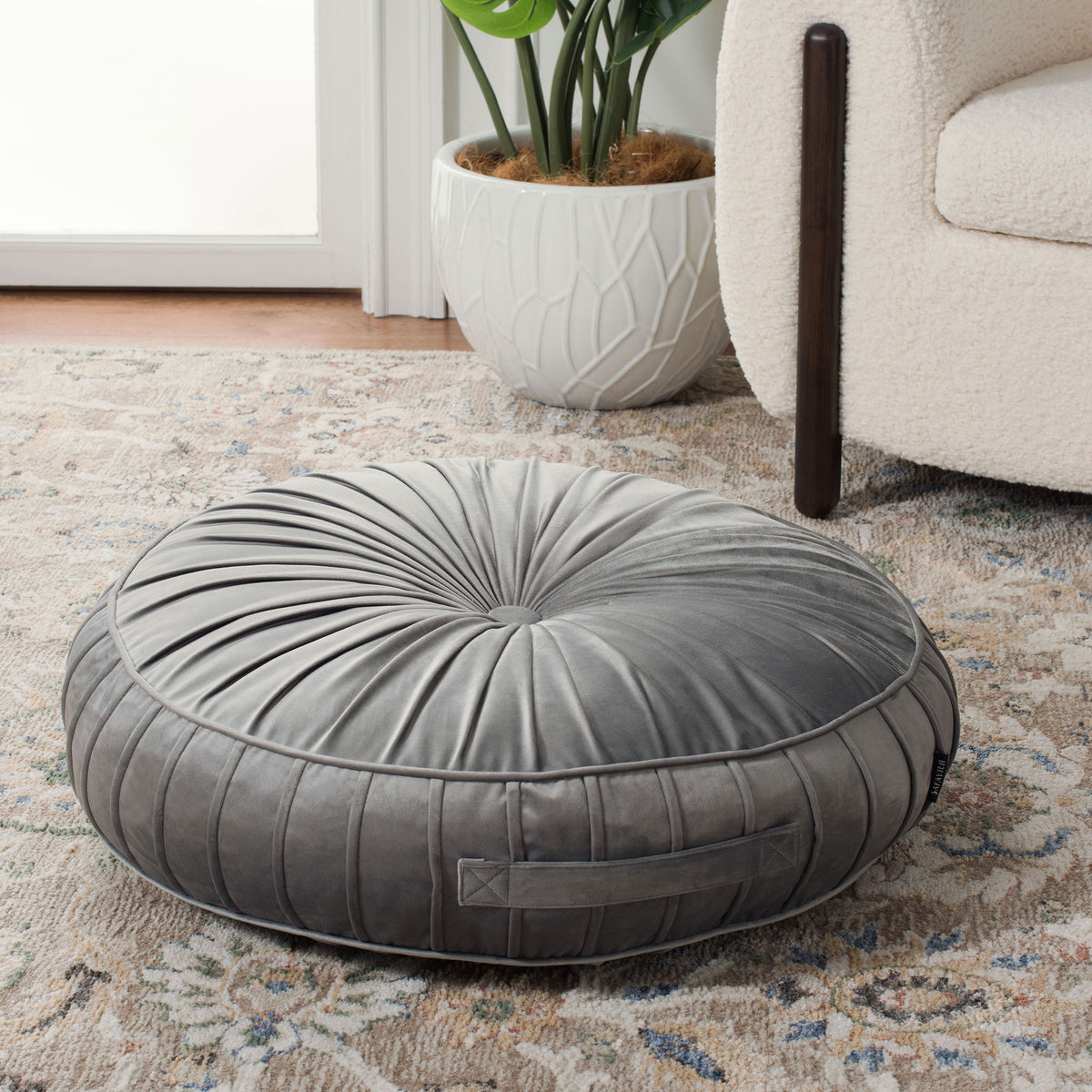 Round gray floor pillow offers plush low seating with radial pleats and a side carrying handle || FLP1000B-2424 || front_angle_room