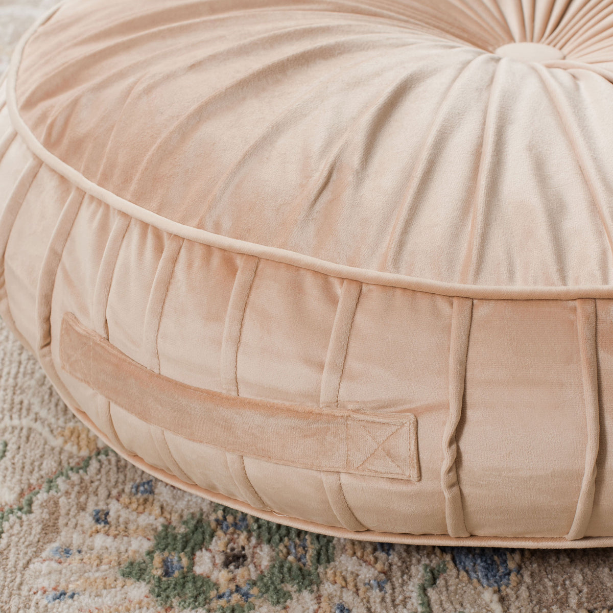 A sewn-in fabric handle and vertical pleats give this champagne floor pillow a tailored edge