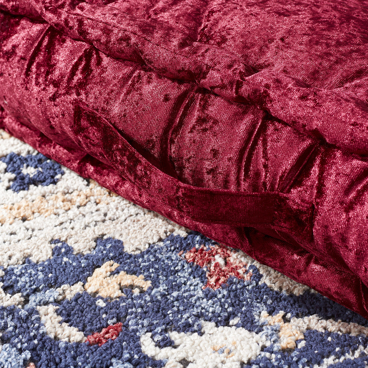 A burgundy fabric handle is sewn into the pillow's thick, velvet-like side. || FLP1001H-1818 || handle_room