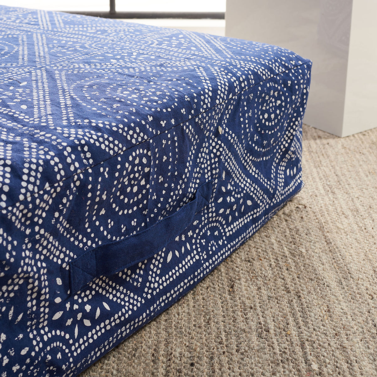 Thick navy floor cushion with white dotted motifs and a stitched fabric side handle || FLP1010A || handle_room