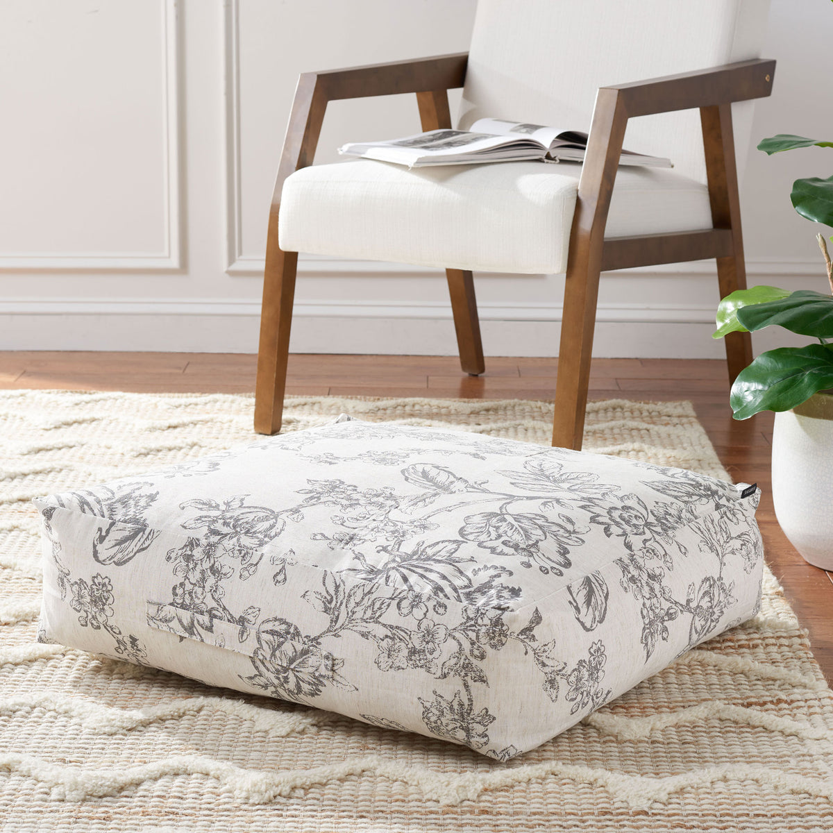 Thick floral floor pillow creates a cushioned spot for lounging beside an armchair. || FLP1011A || front_angle_room