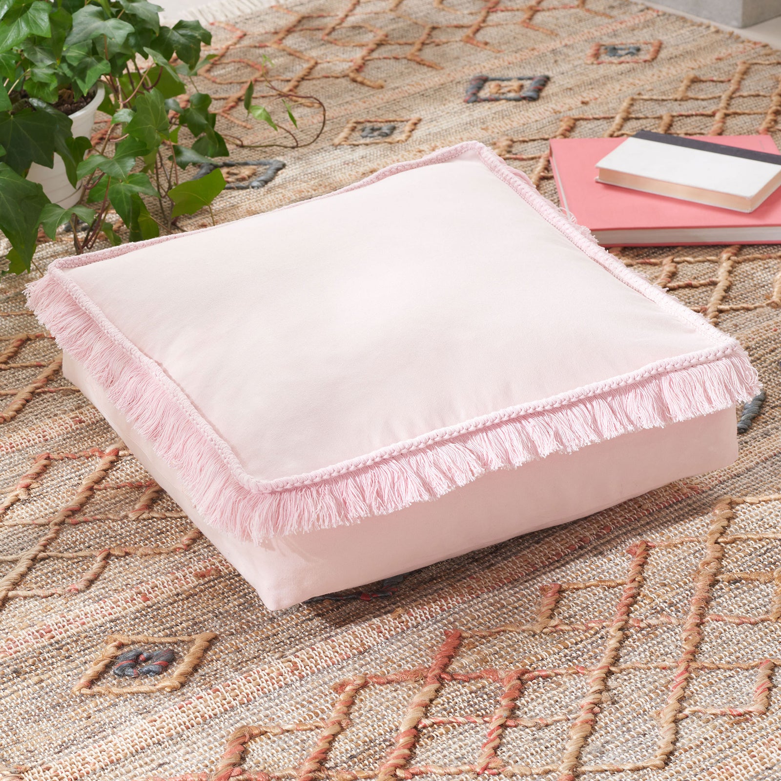 A plump pink floor cushion brings soft color and fluttering fringe to casual seating. || FLP1018C || front_angle_room