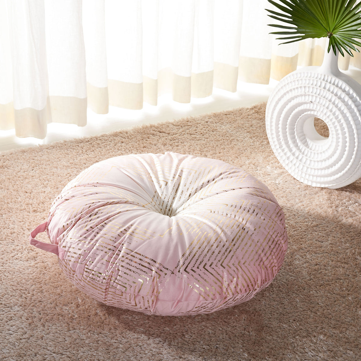 Pale pink floor pillow with luminous gold chevrons offers a soft, inviting seat