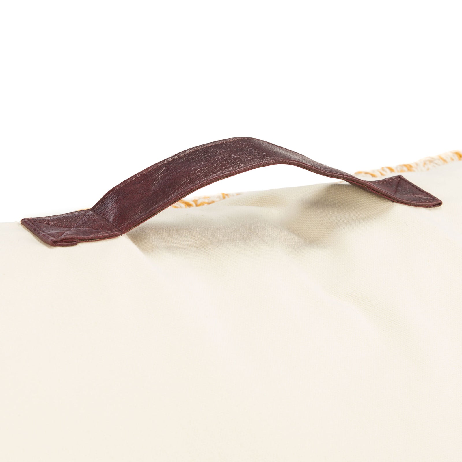 A sturdy brown carrying handle is stitched to the soft ivory fabric of the floor pillow || FLP3000A || handle_studio
