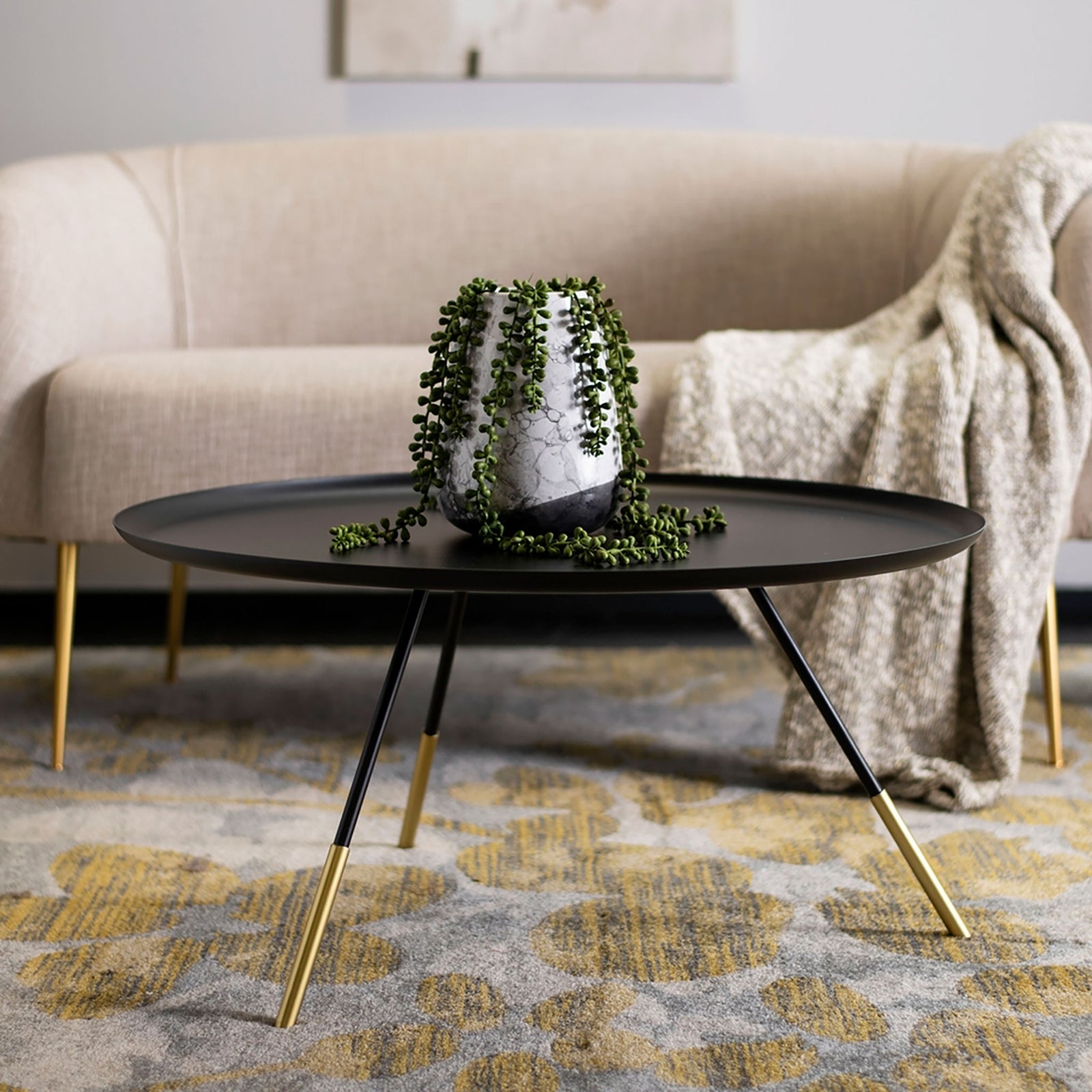 Contemporary black tray-style coffee table with gold-tipped legs brings refined style to a cozy living space. || FOX4525A || front_angle_room